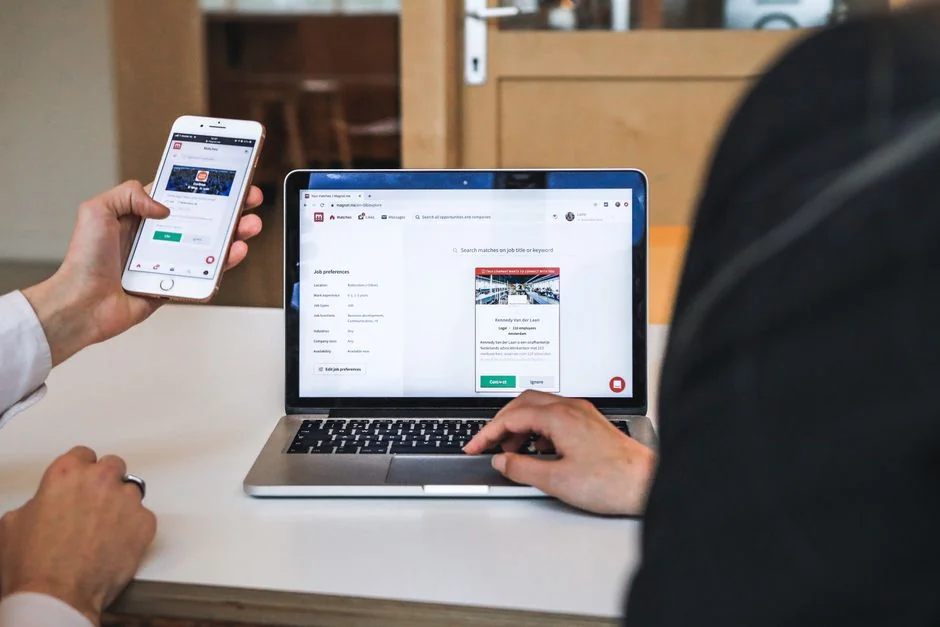 A sleek office desk setup featuring Apple devices: iMac, MacBook, and iPad.